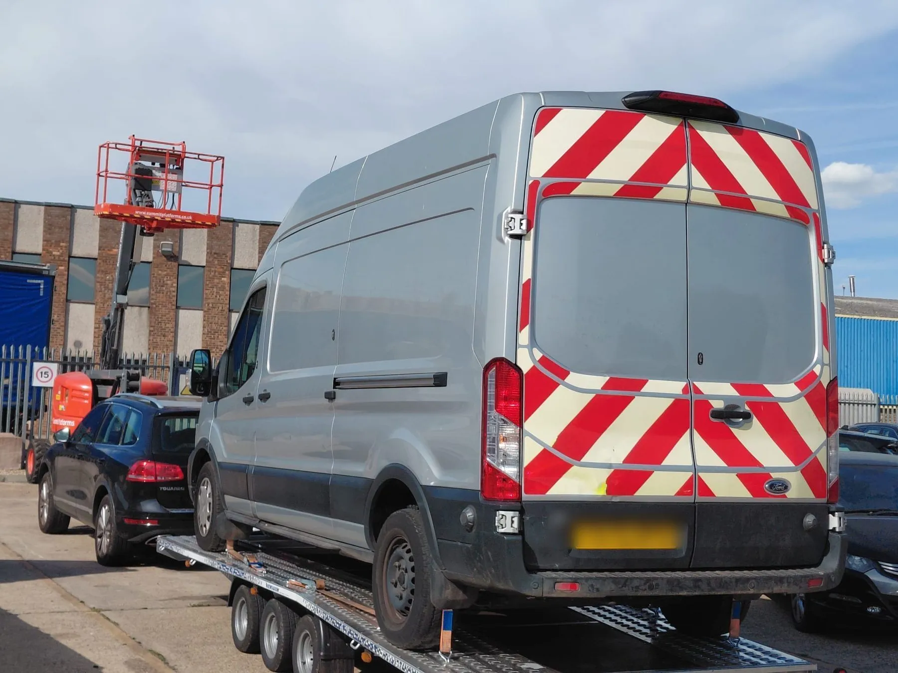 Large Ford Transit van strapped down on the VP Autos transporter